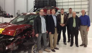 The partners met at the VRC on February 14 to plan out the Locata installation. From left are Robert “Bo” Jones, IIHS engineer; Paul Perrone, president, Perrone Robotics; Geoff Hoekstra, business development, Perrone Robotics; Adrian Lund, president, IIHS; David Zuby, chief research officer, IIHS; Nunzio Gambale, Locata CEO; Jimmy LaMance, Locata. The auto is the result of a crash test conducted that day.