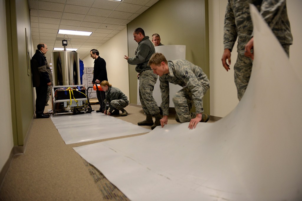 Personnel with the U.S. Naval Observatory-Detachment Colorado and 2nd Space Operations Squadron move the rubidium fountain clock into its new home Tuesday at Schriever Air Force Base. The USNO monitors the GPS constellation and provides time offsets to the 2nd Space Operations Squadron for their daily navigation uploads to each individual GPS satellite. (U.S. Air Force photo/Christopher DeWitt).