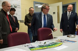 Canadian Science Minister Ed Holder looks at GPS World magazine, which has featured Innovation columns edited by Richard Langley for more than two decades.