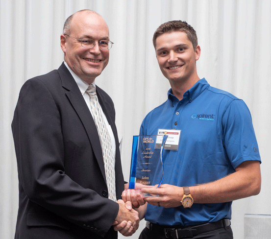 Defense takes center stage at Leadership Awards. John Raquet, AFIT, accepts 2018 Leadership Award for Services from Justin Eldredge, Spirent Federal. (Melanie Beus photo)