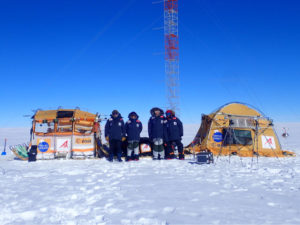 The expedition team with their Inuit WindSled at the high point of Dome Fuji. Note the ESA logo on the left tent of the WindSled. (Photo: Inuit WindSled via ESA)