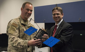 Johnathon Caldwell, Lockheed Martin Space vice president of navigation systems, right, presents Lt. Col. Stephen Toth, 2nd Space Operations Squadron commander, with a GPS III model satellite as a token of appreciation for the 2nd SOPS critical mission in space at Schriever Air Force Base, Colorado, July 29, 2019. The squadron performed its first station keeping maneuver on a GPS III satellite May 14, 2020, at Schriever AFB. (Photo: U.S. Air Force/1st Class Jonathan Whitely)