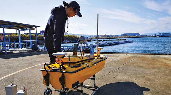 Weichao Liu, a member of CHC Navigation’s technical support staff, prepares to launch an Apache6 unmanned surface vessel (USV), also known as a marine drone. (Photo: CHC Navigation)