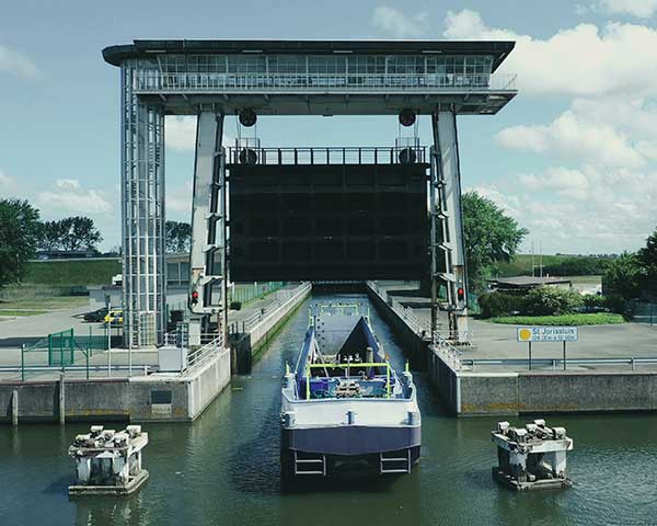 An autonomous freight barge moves through a lock. The barge is equipped with Septentrio GNSS positioning via Seafar navigation. (Photo: Seafar)