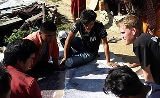 FIG Volunteer Community Surveyor working with locals to discuss parcel possession. (Photo: FIG Young Surveyors)