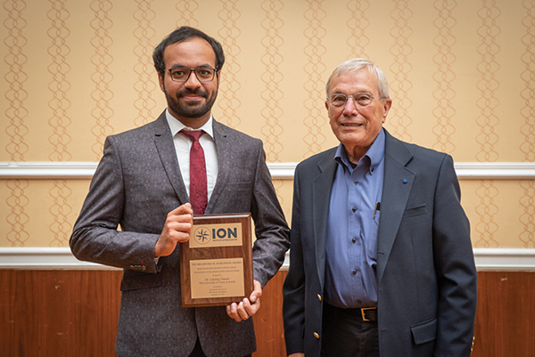 At the ION GNSS+ 2021 conference in St. Louis, Missouri, the annual meeting of the Satellite Division of the Institute of Navigation, Brad Parkinson bestowed Lakshay Narula with the division’s Bradford W. Parkinson Award for his Ph.D. thesis “Towards Secure & Robust PNT for Automated Systems” at the University of Texas at Austin. The award honors Parkinson, known as the “father of GPS,” for his leadership in establishing both GPS and the Satellite Division of the ION. Narula is now an applied scientist at Amazon Lab126 in Sunnyvale, California, where he researches robust navigation and state estimation methods for robots, from self-driving cars to aerospace applications. (Photo: ION)