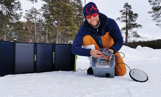 Gilles Denis shows the AsteRx-SB receiver and the PolaNt-x MF antenna that are accompanying the explorers for the entire journey, so that data can be collected at various locations along the way. The receiver is powered by solar panels. (Photo: Nanok Expedition)