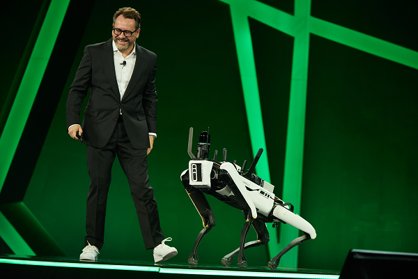 Burkhard Boeckem and a Boston Dynamics robot dog share insights into smart digital realities. (Photo: Hexagon)