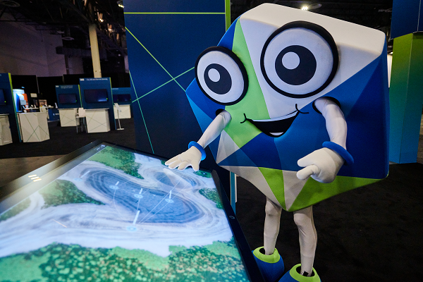The Hexagon mascot peruses a map during HxGN LIVE 2022. (Photo: Hexagon)