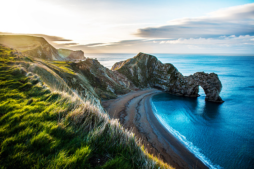 Durdle Door on the beach in Dorset County, United Kingdom. (Photo: Fonrimso/iStock/Getty Images Plus)