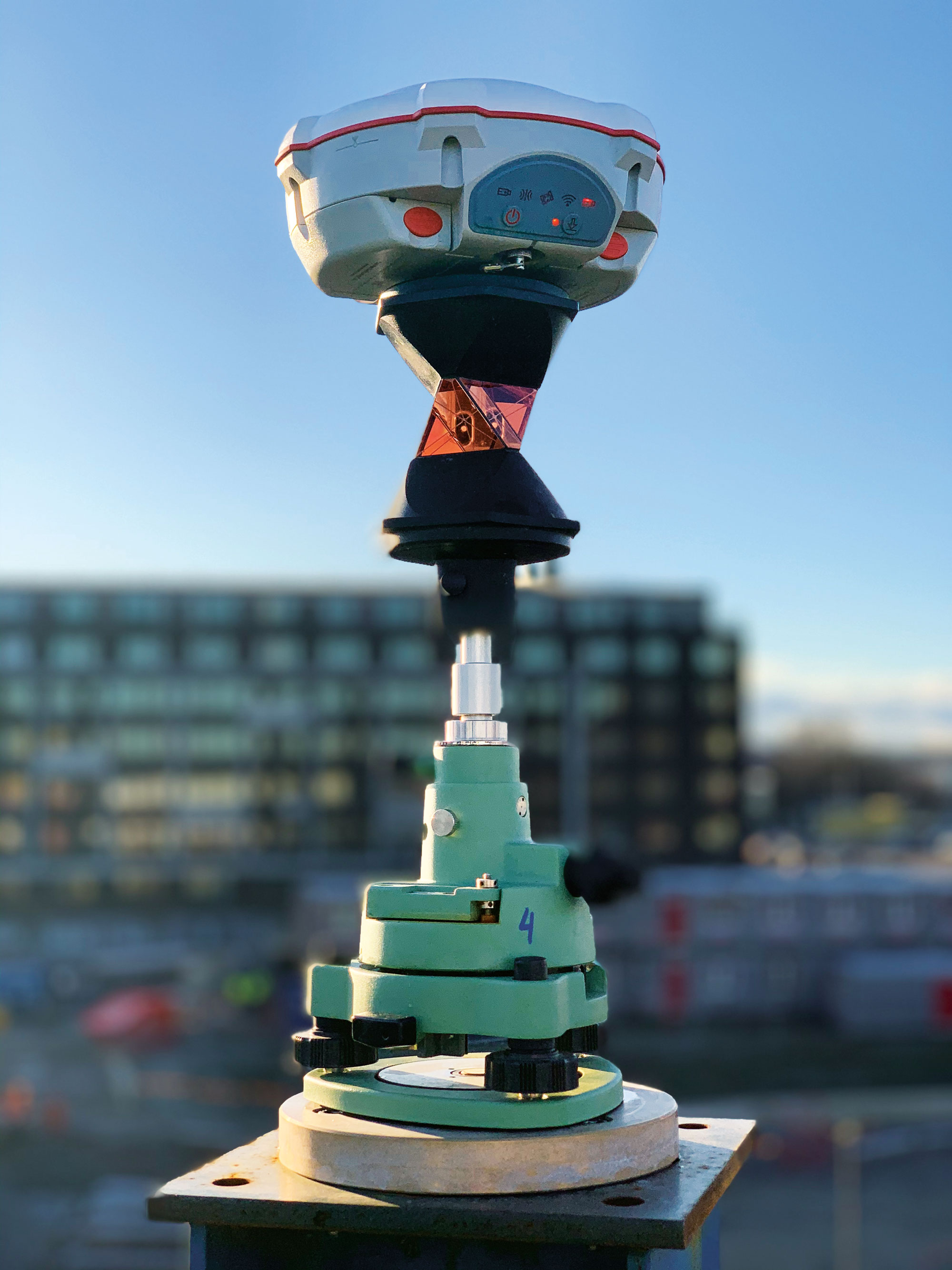 A SinoGNSS multi-constellation T300 GNSS receiver and a 360° prism mounted at the top of a building under construction. (Photo: ComNav Technology)