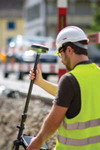 A utility technician using the Leica GS05 GNSS receiver for the surveying and utility industries, which Leica released in September. (Photo: Leica Geosystems)