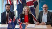 Simon Reynolds (left) engineering manager for SouthPAN; Melissa Harris, CEO of Geoscience Australia (center); and Stuart Bryce, vice president of Capture and Strategy, Viasat, sign the contract in Canberra, Australia.(Photo: Viasat)