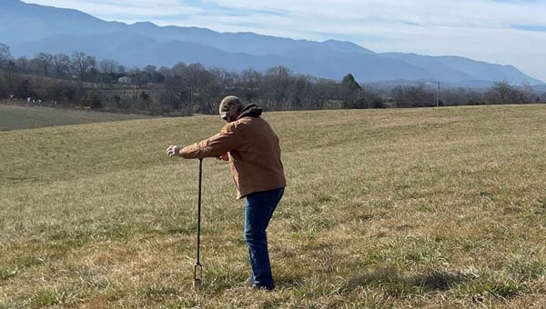 An inspector takes a soil sample to understand the makeup and condition of the soil. (Image courtesy of TDEC)